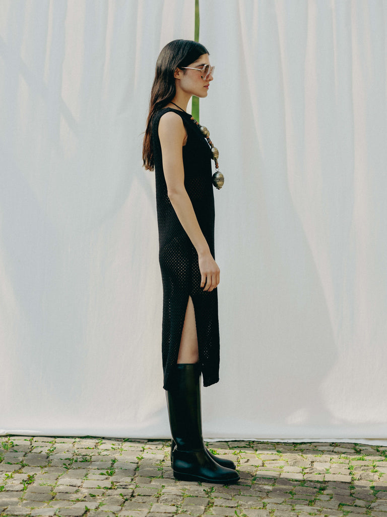 Sassy net knit dress crafted in Switzerland, featuring a classic round neckline, fitting armholes, and stylish side slits, made from organic cotton, perfect for evening wear or summer outings over swimwear