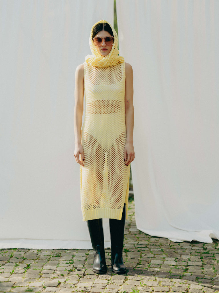 Sassy net knit dress crafted in Switzerland, featuring a classic round neckline, fitting armholes, and stylish side slits, made from organic cotton, perfect for evening wear or summer outings over swimwear