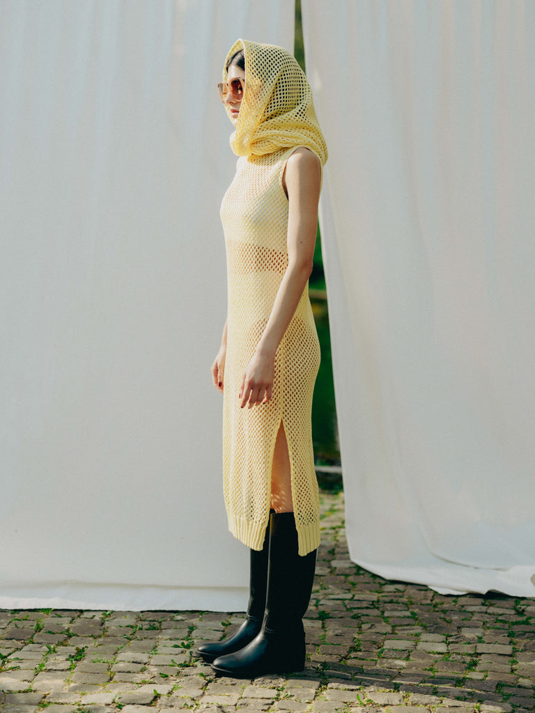 Sassy net knit dress crafted in Switzerland, featuring a classic round neckline, fitting armholes, and stylish side slits, made from organic cotton, perfect for evening wear or summer outings over swimwear