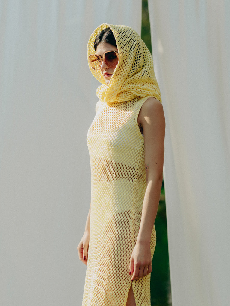 Elegant net knit dress crafted in Switzerland, featuring a classic round neckline, fitting armholes, and stylish side slits, made from organic cotton, perfect for evening wear or summer outings over swimwear.