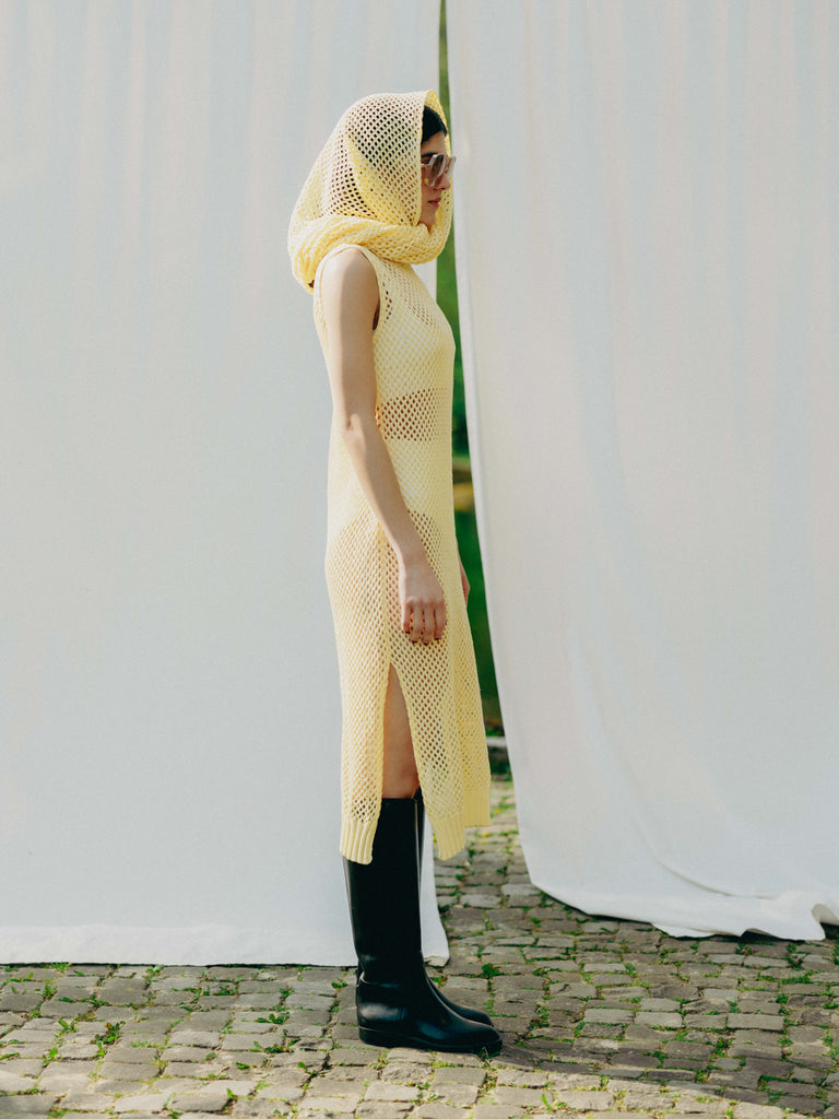 Sassy net knit dress crafted in Switzerland, featuring a classic round neckline, fitting armholes, and stylish side slits, made from organic cotton, perfect for evening wear or summer outings over swimwear