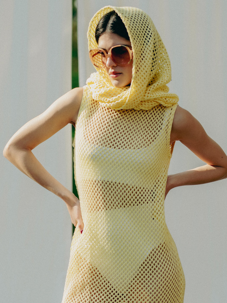 Sassy net knit dress crafted in Switzerland, featuring a classic round neckline, fitting armholes, and stylish side slits, made from organic cotton, perfect for evening wear or summer outings over swimwear