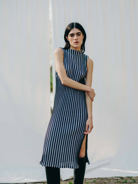 Swiss-made unique rib-knit cotton dress with pleated design, elegant high neckline, and chic side slits, perfect for evening wear or casual style, sustainable and made to order.