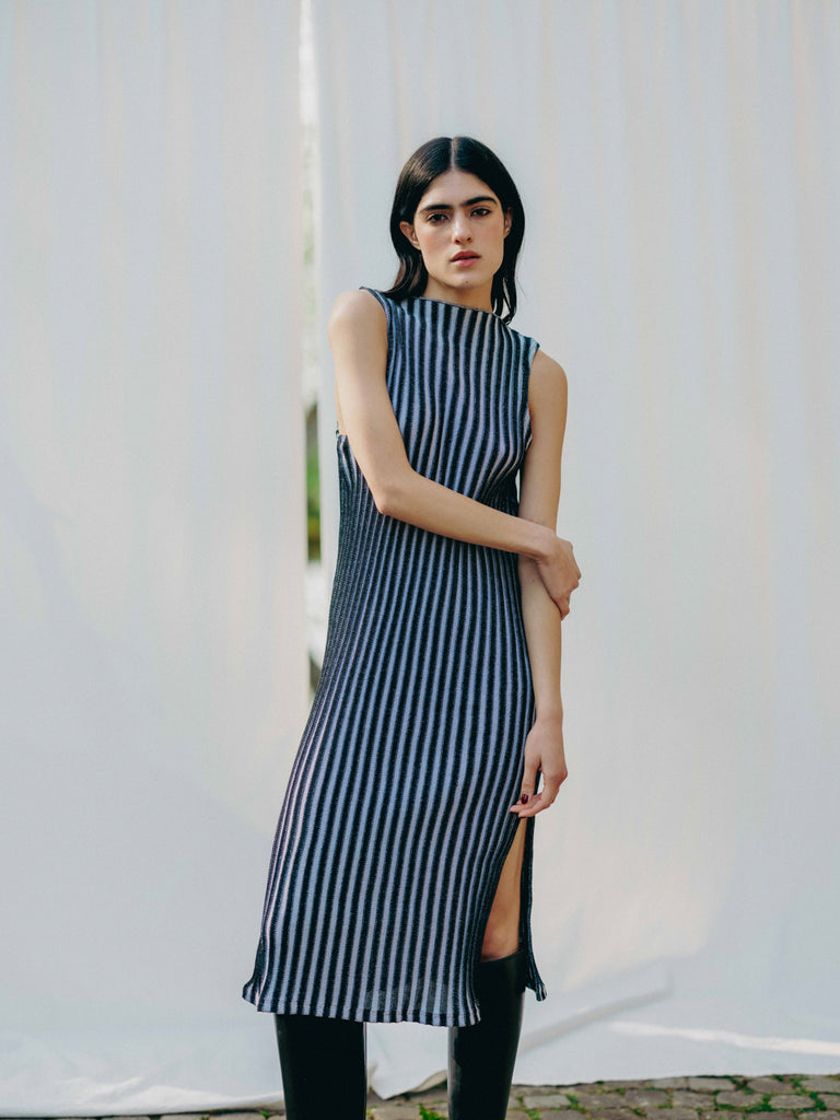 Swiss-made unique rib-knit cotton dress with pleated design, elegant high neckline, and chic side slits, perfect for evening wear or casual style, sustainable and made to order.