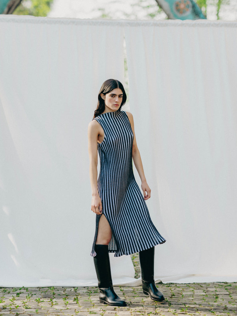 Swiss-made unique rib-knit cotton dress with pleated design, elegant high neckline, and chic side slits, perfect for evening wear or casual style, sustainable and made to order.