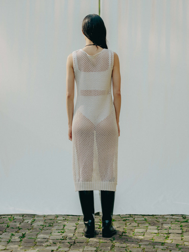 Sassy net knit dress crafted in Switzerland, featuring a classic round neckline, fitting armholes, and stylish side slits, made from organic cotton, perfect for evening wear or summer outings over swimwear