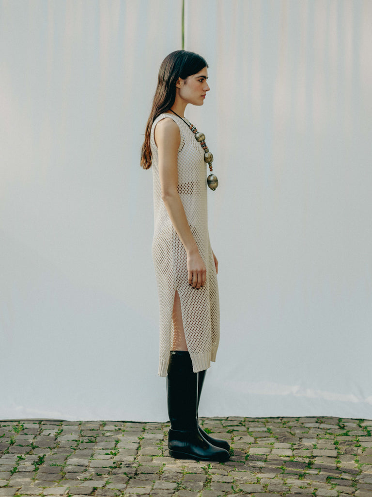 Sassy net knit dress crafted in Switzerland, featuring a classic round neckline, fitting armholes, and stylish side slits, made from organic cotton, perfect for evening wear or summer outings over swimwear