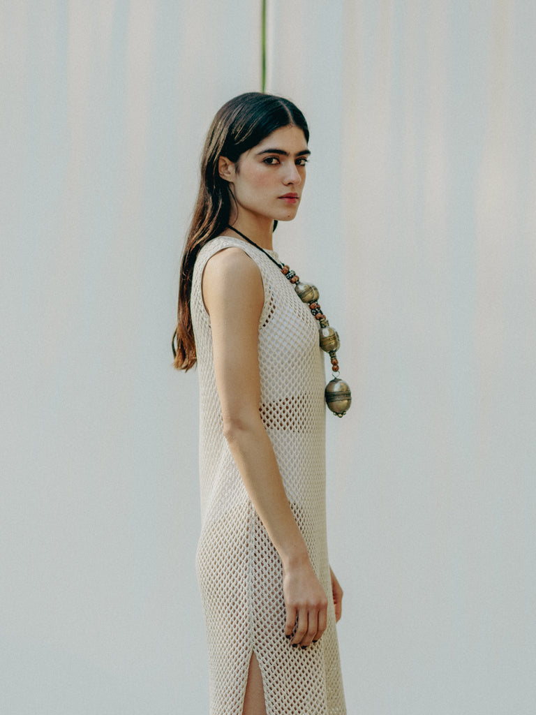 Sassy net knit dress crafted in Switzerland, featuring a classic round neckline, fitting armholes, and stylish side slits, made from organic cotton, perfect for evening wear or summer outings over swimwear