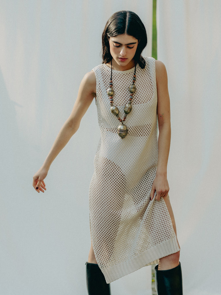 Sassy net knit dress crafted in Switzerland, featuring a classic round neckline, fitting armholes, and stylish side slits, made from organic cotton, perfect for evening wear or summer outings over swimwear