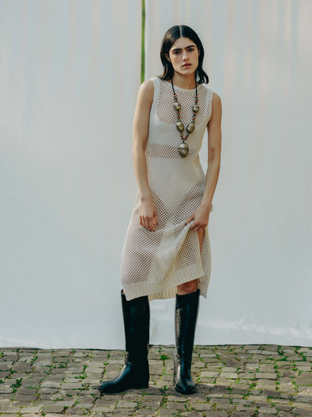 Sassy net knit dress crafted in Switzerland, featuring a classic round neckline, fitting armholes, and stylish side slits, made from organic cotton, perfect for evening wear or summer outings over swimwear