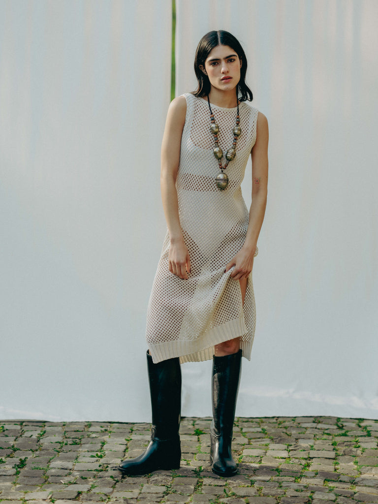 Sassy net knit dress crafted in Switzerland, featuring a classic round neckline, fitting armholes, and stylish side slits, made from organic cotton, perfect for evening wear or summer outings over swimwear