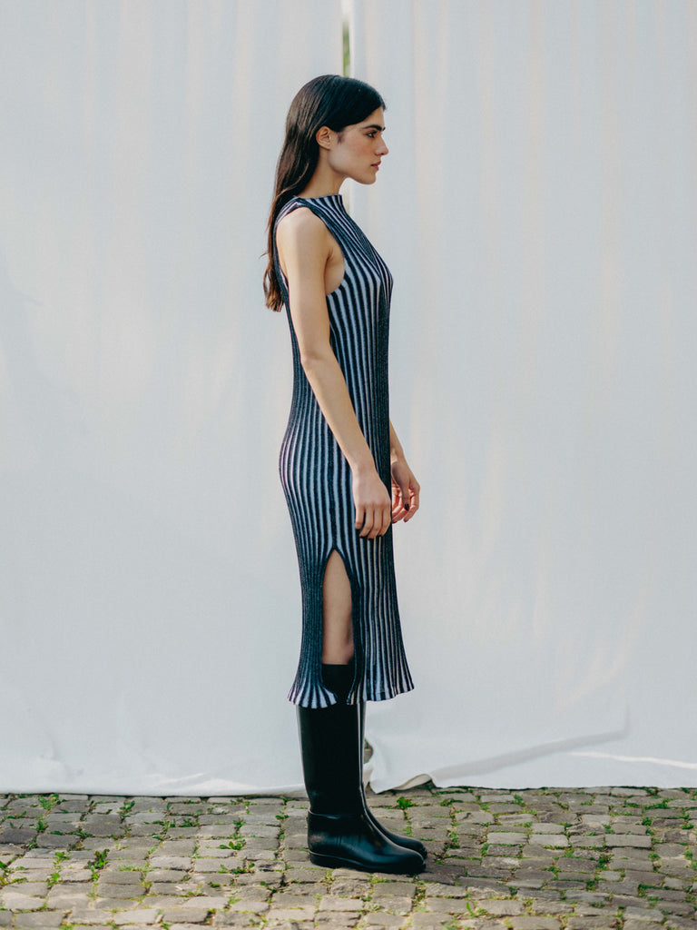 Swiss-made unique rib-knit cotton dress with pleated design, elegant high neckline, and chic side slits, perfect for evening wear or casual style, sustainable and made to order.
